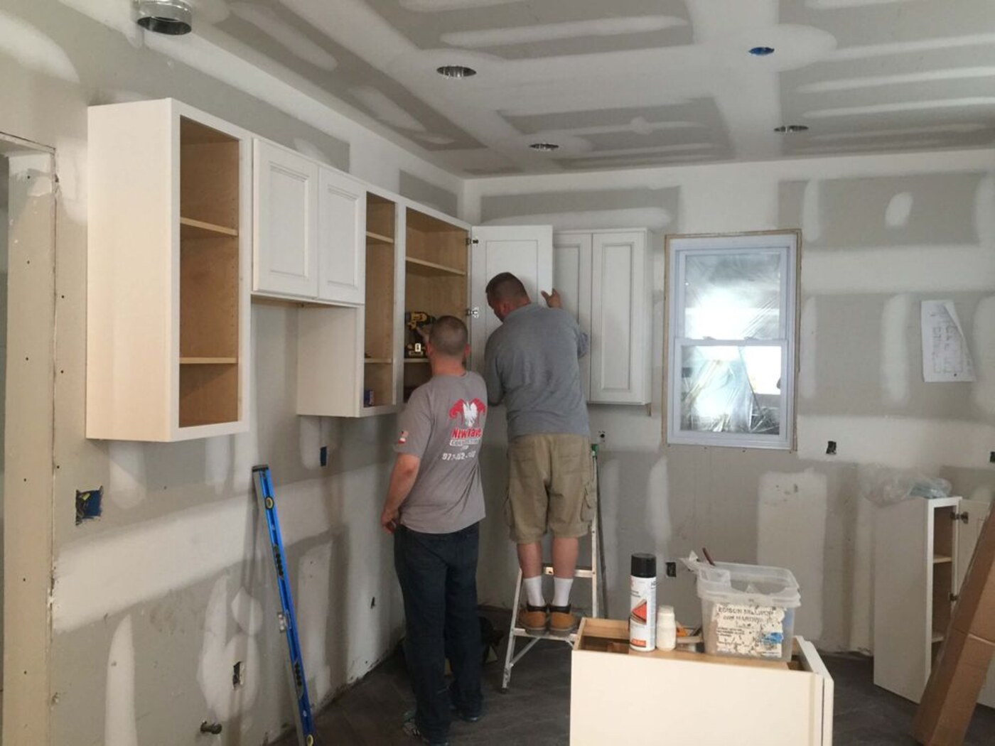 Crew setting wall cabinets during an install