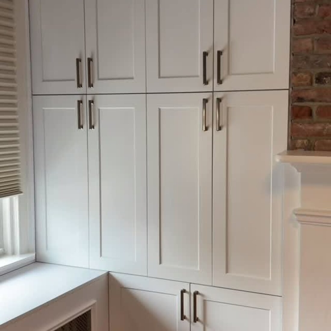 White shaker cabinets against exposed brick in Hoboken